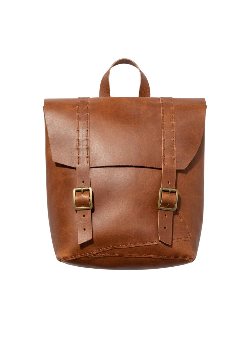 Goa Nomads rustic brown organic goat leather backpack with buckle straps and vintage stitching.