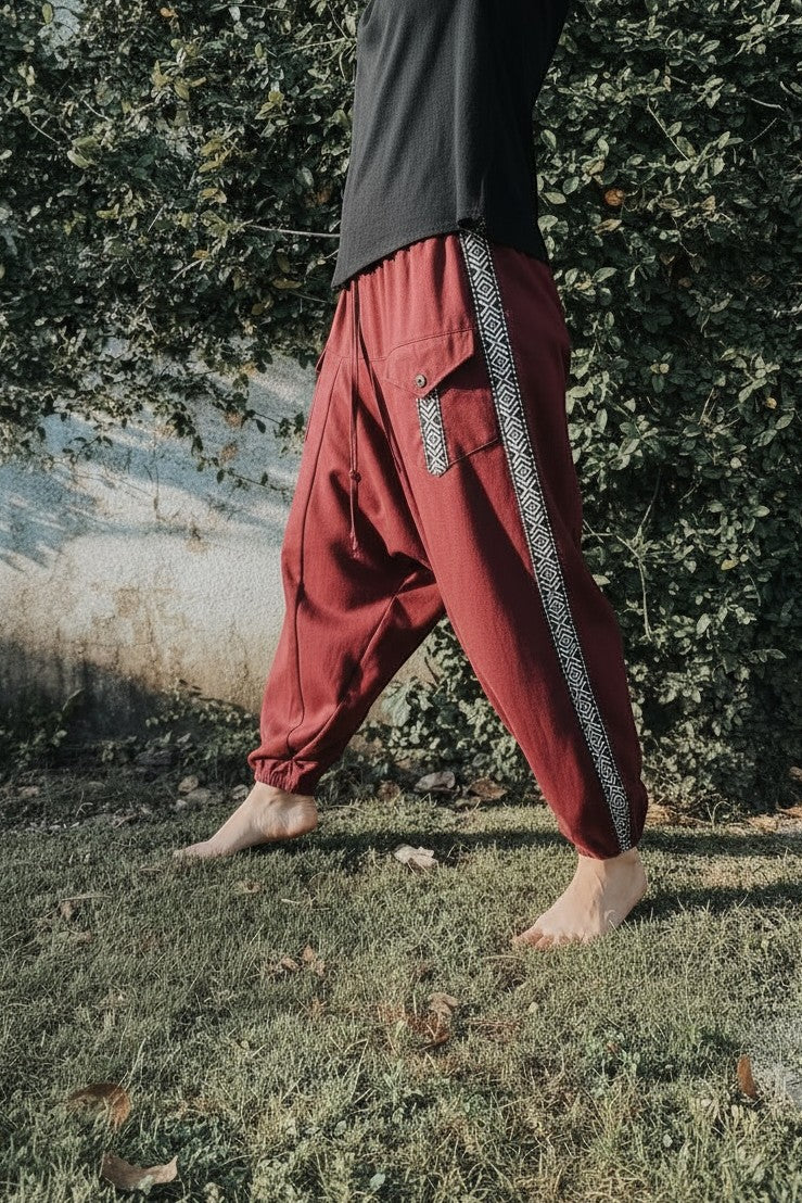 Goa Nomads burgundy linen Aladdin pants with ethnic side trim and asymmetric pockets.