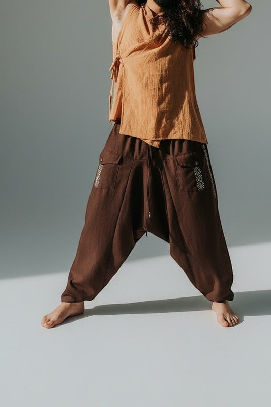 Calça Aladim Goa Nomads em linho marrom com fita étnica lateral e bolsos assimétricos.