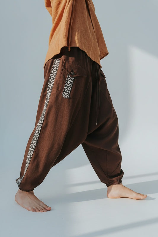 Calça Aladim Goa Nomads em linho marrom com fita étnica lateral e bolsos assimétricos.