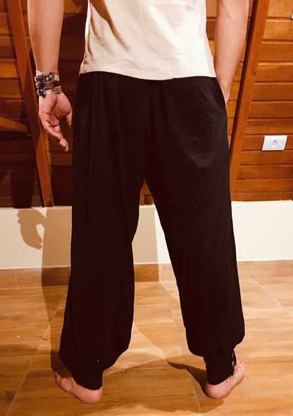 Calça hindu preta em malha ecológica Goa Nomads, com elástico na cintura, bolsos e botões de coco natural nos tornozelos.