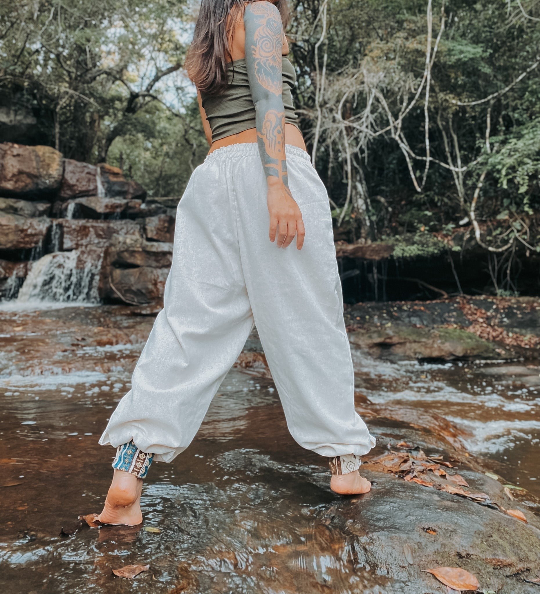 Goa Nomads white linen blend Ganesha pants with patterned ankle cuffs and waistband. Loose fit, ideal for yoga or casual wear.